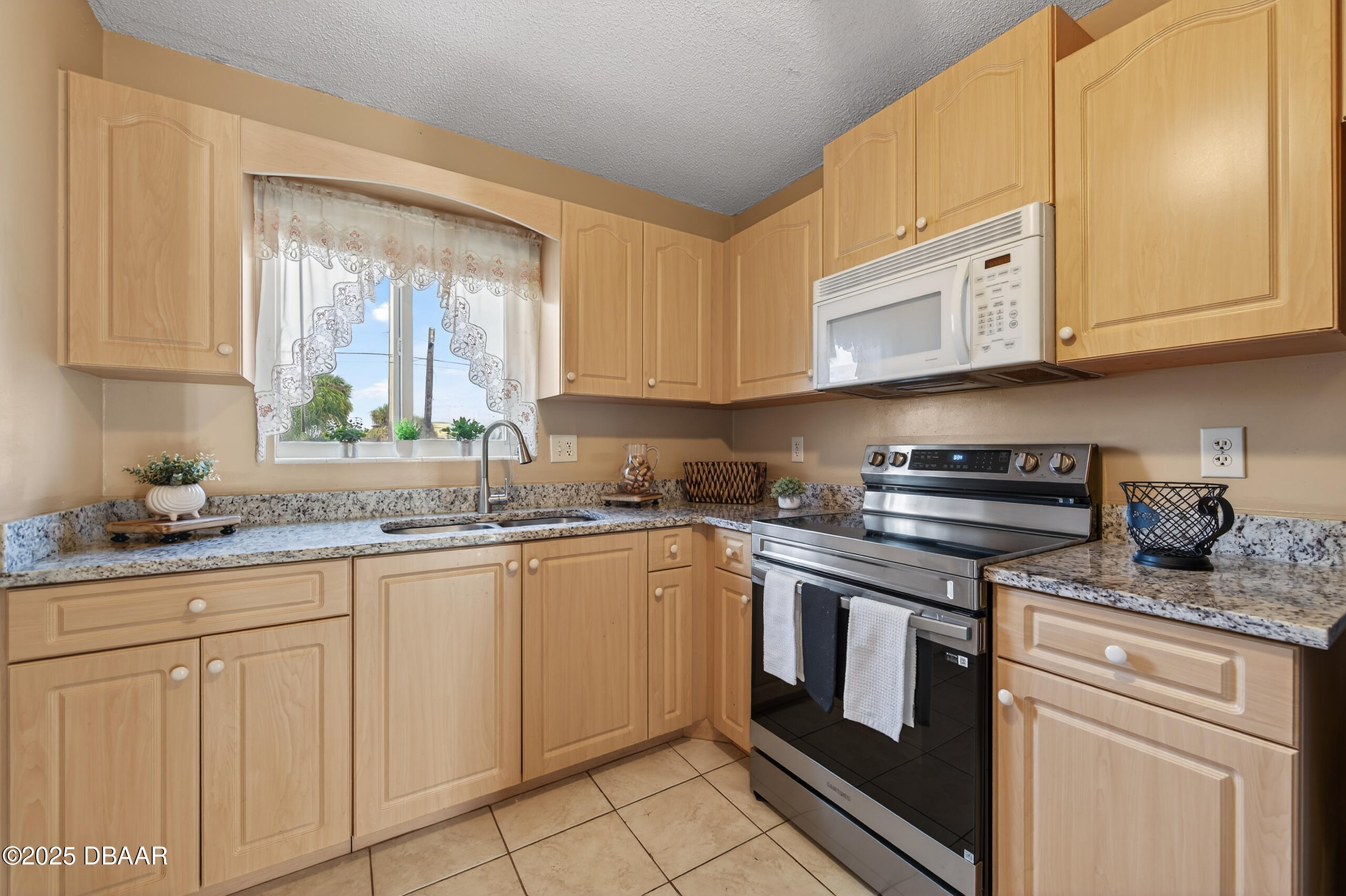 2711 North Halifax Avenue, Unit 282 Daytona Beach, FL 32118 - Photo 7 of 18 a kitchen with granite countertop white cabinets and white appliances