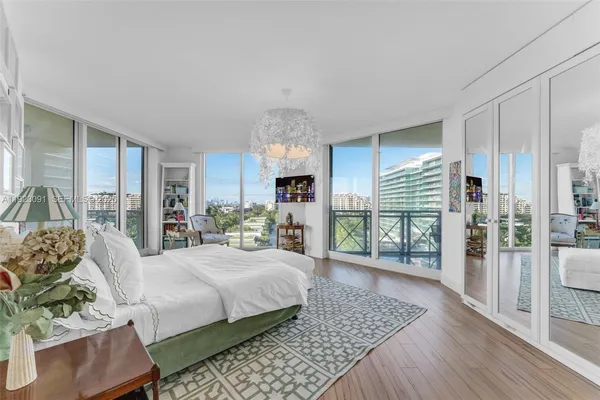 a living room with furniture a large window and wooden floor