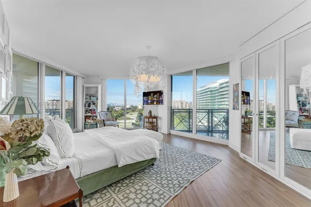 a living room with furniture a large window and wooden floor