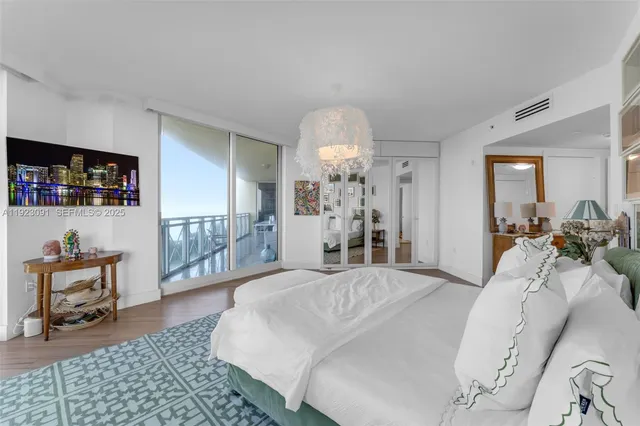 a living room with hardwood floor and large windows