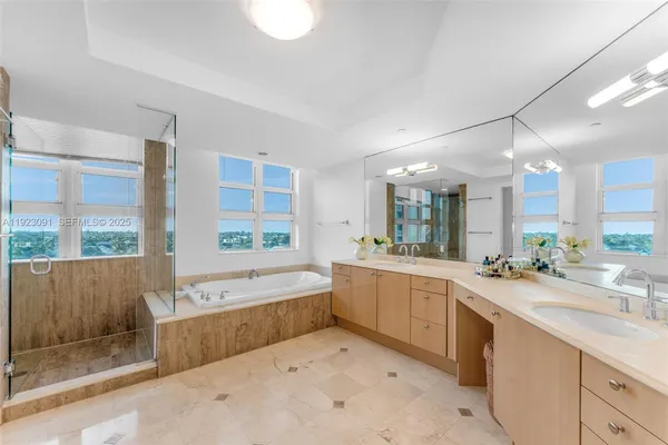 a large white bathroom with a large tub sink vanity and granite