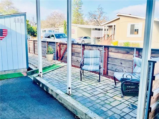 an outdoor sitting area with couch and wooden fence