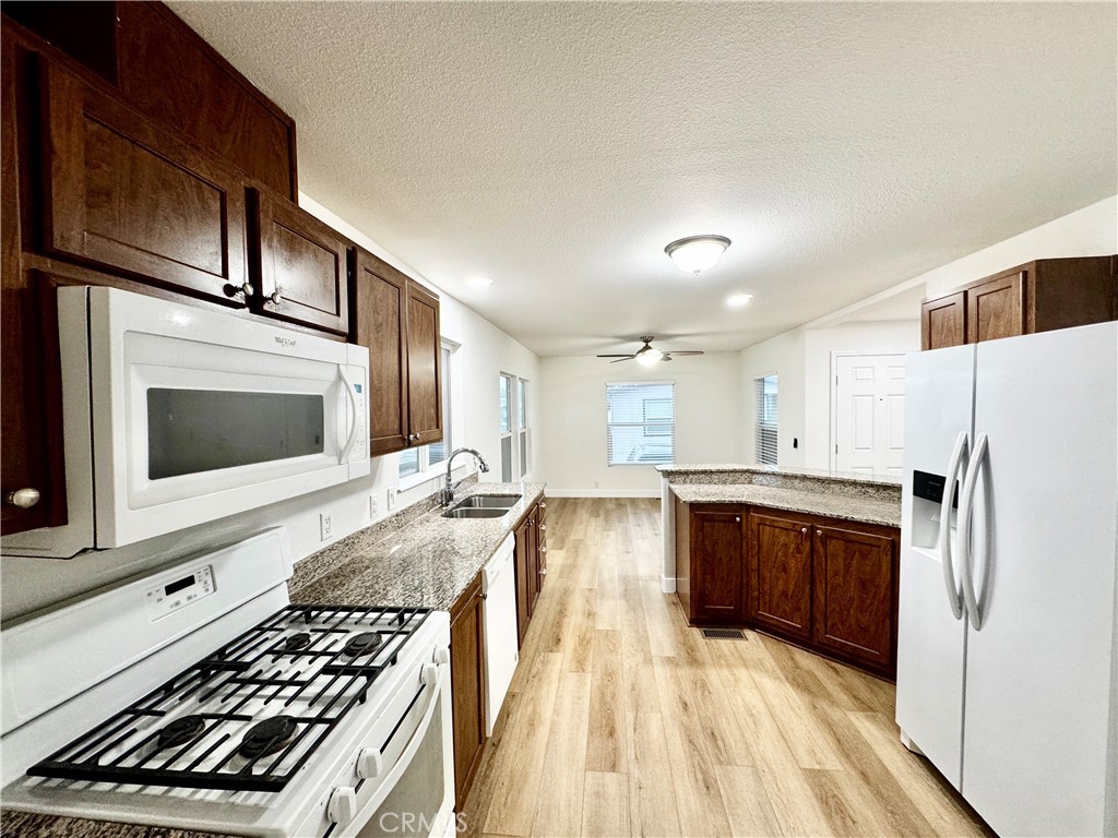 6154 South Walnut Street, Unit 40 Loomis, CA 95650 - Photo 5 of 15 a kitchen with stainless steel appliances granite countertop a stove a sink and a microwave