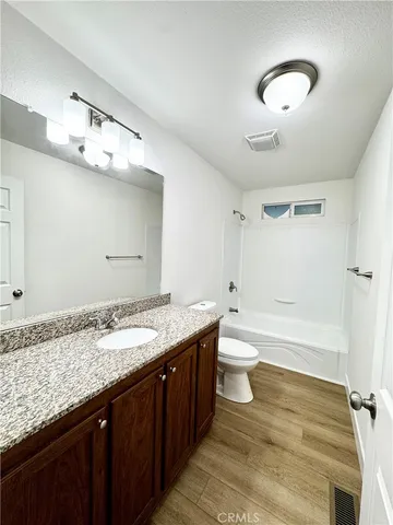 a bathroom with a granite countertop double vanity sink and a mirror