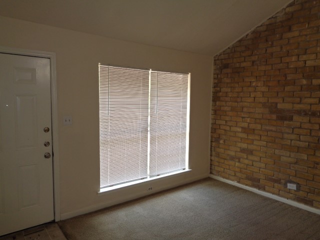 701 Foster Drive, Unit 4 Conroe, TX 77301 - Photo 2 of 11 a view of an empty room with brick wall