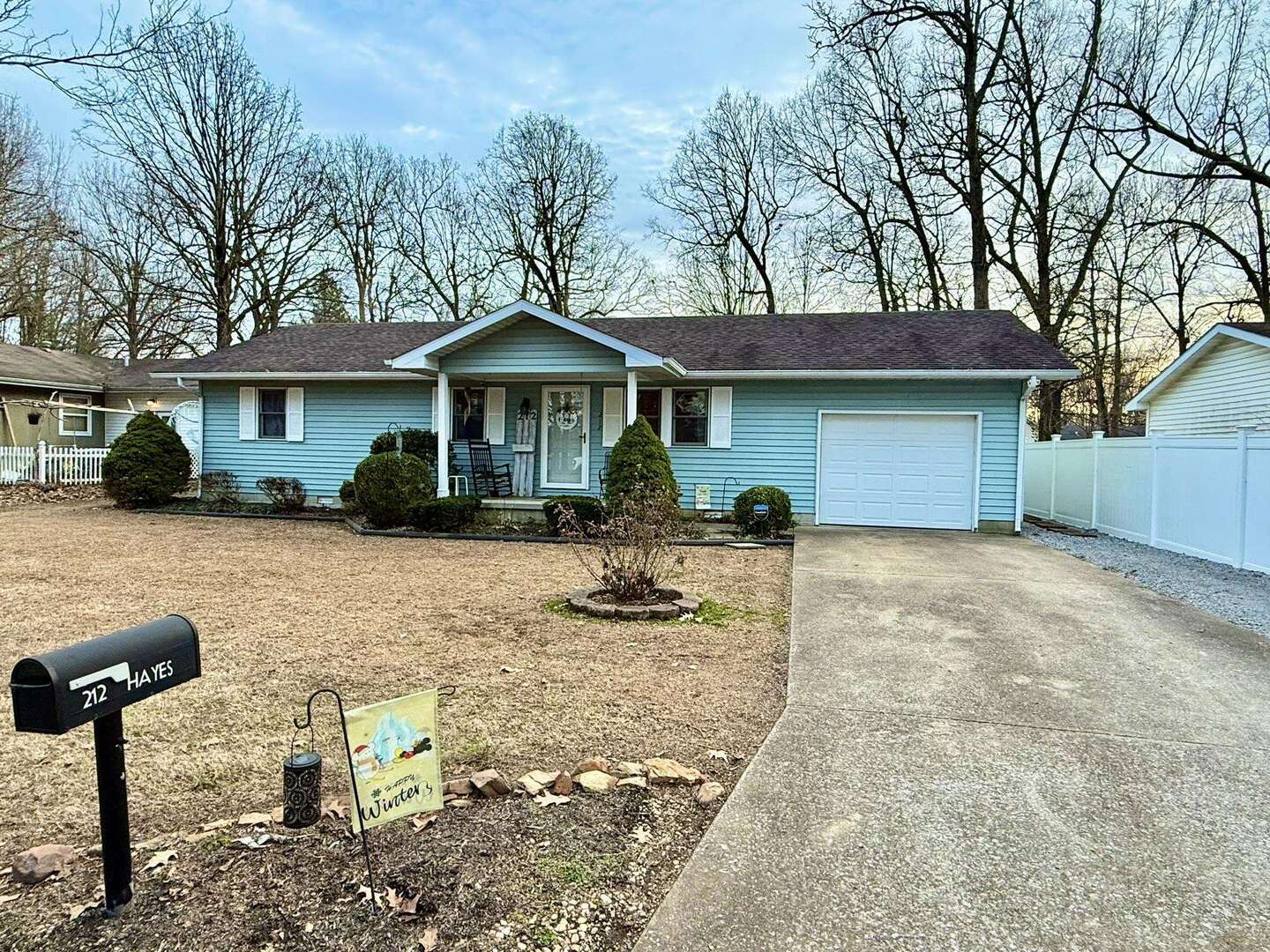 a front view of a house with a yard and potted plants