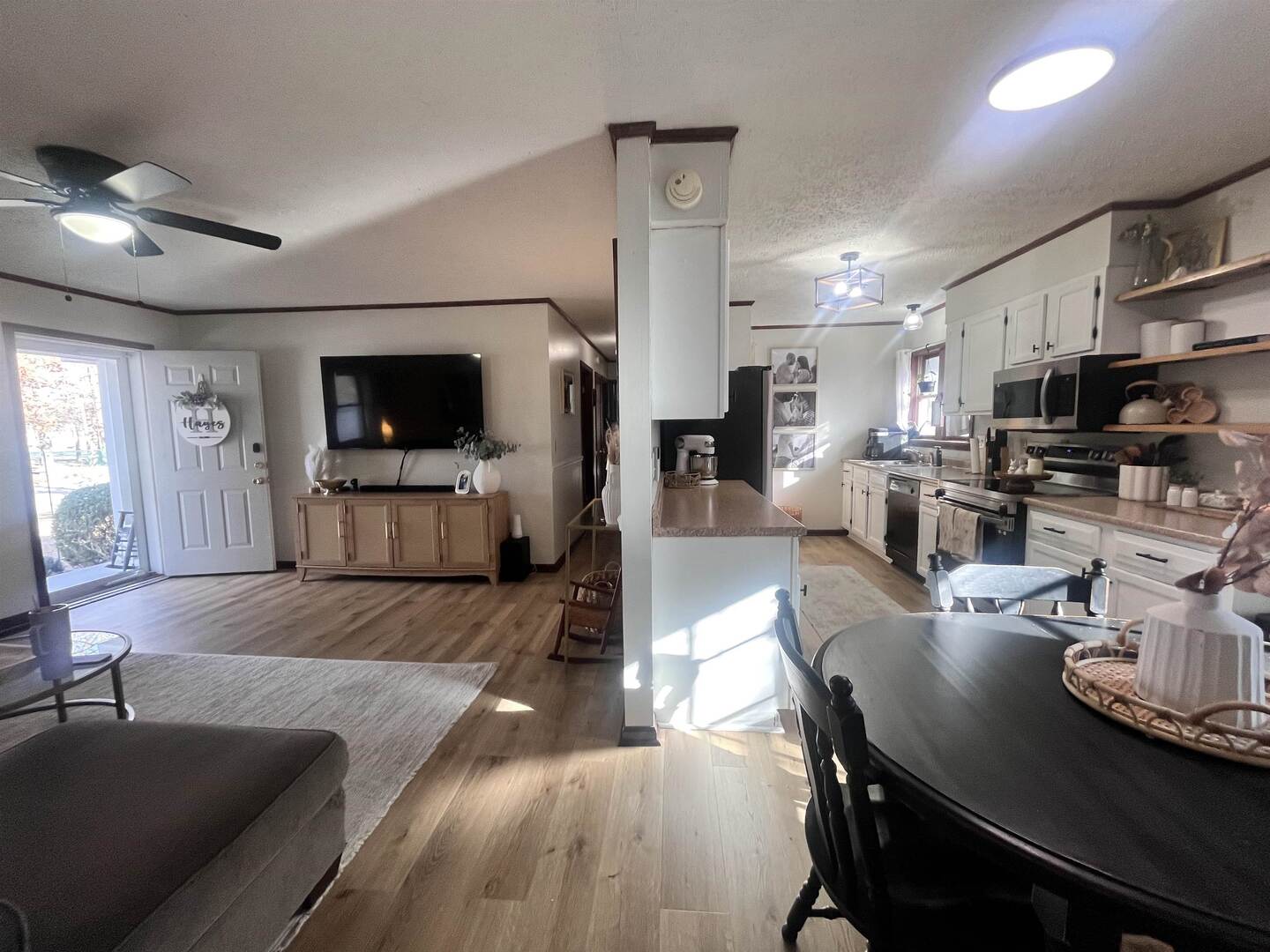 212 East 19th Street Metropolis, IL 62960 - Photo 14 of 30 a living room with stainless steel appliances a dining table a flat screen tv and kitchen view