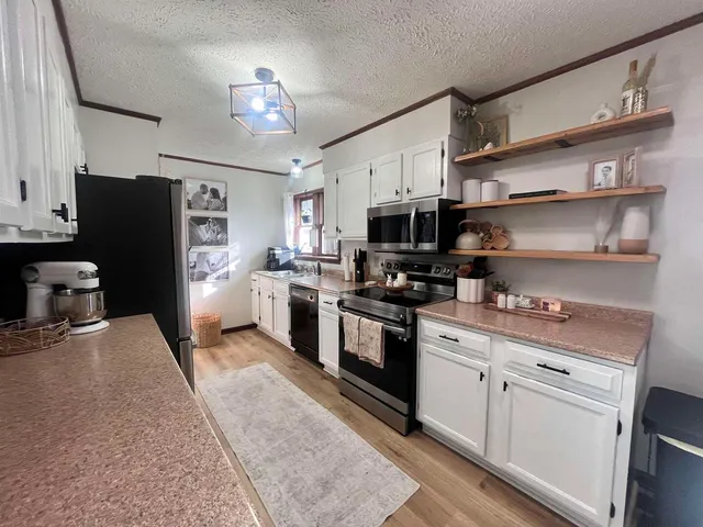 a kitchen with stainless steel appliances a stove refrigerator sink and microwave