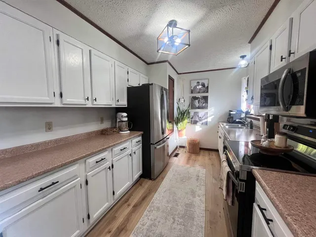 a kitchen with stainless steel appliances granite countertop a refrigerator stove microwave and sink