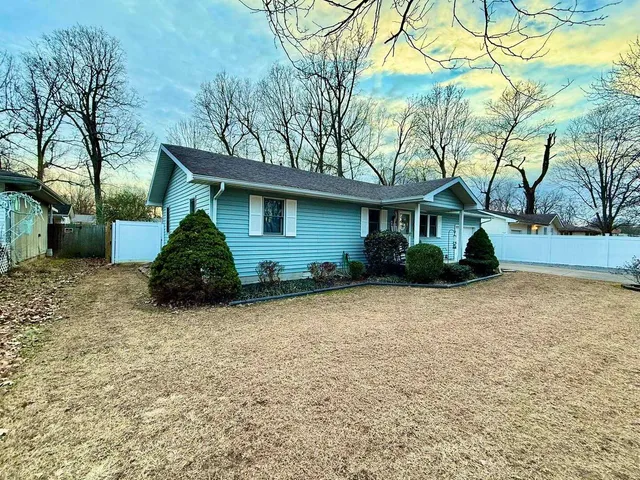 a view of a house with backyard and trees