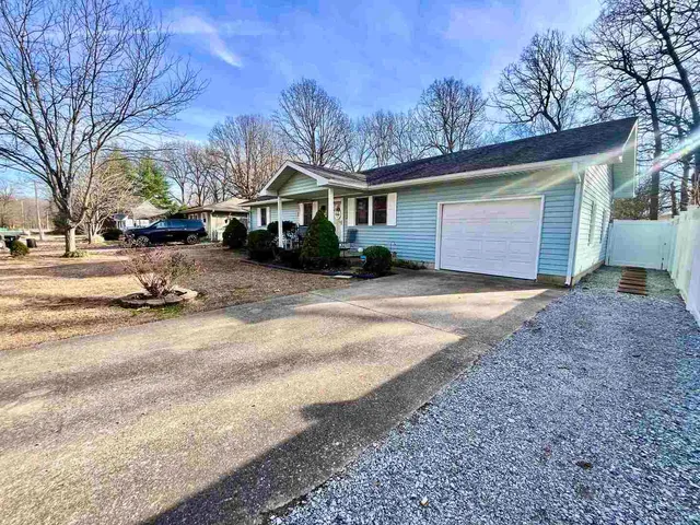 a front view of a house with a yard covered with snow