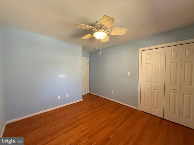 an empty room with closet and wooden floor