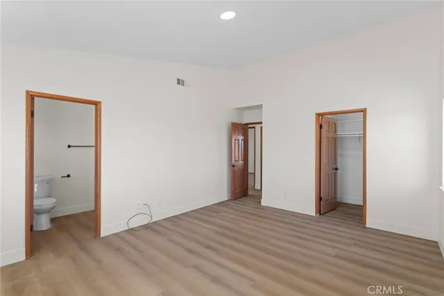 a big room with wooden floor and a bathroom