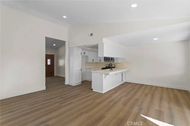 a kitchen with a refrigerator and white cabinets