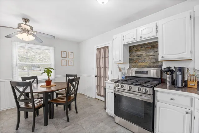 a kitchen with stainless steel appliances a stove a table and chairs