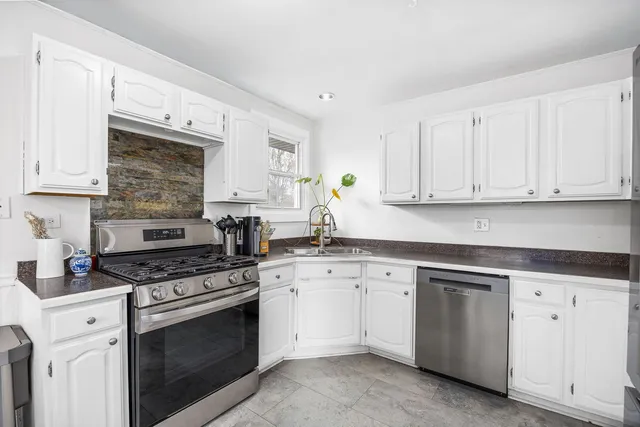 a kitchen with white cabinets and appliances