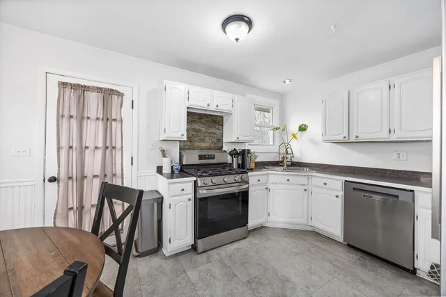 a kitchen with white cabinets and stainless steel appliances