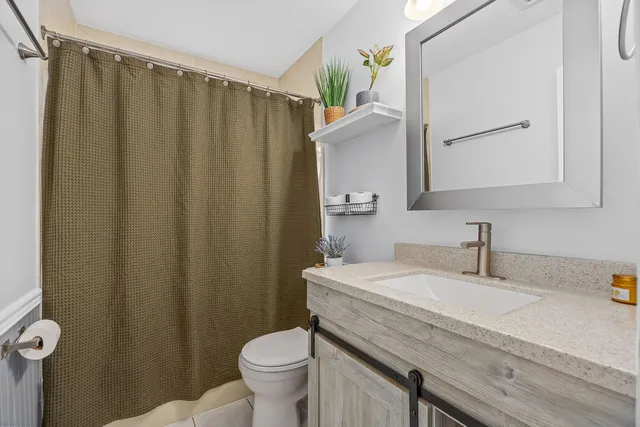 a bathroom with a toilet a sink and a shower curtain
