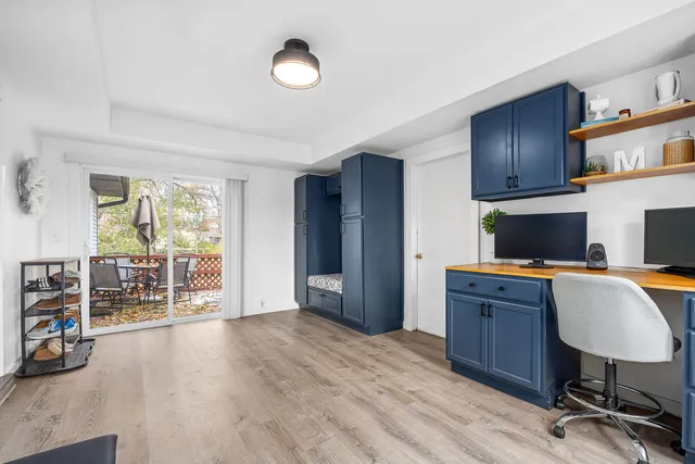a view of a workspace with furniture and a window