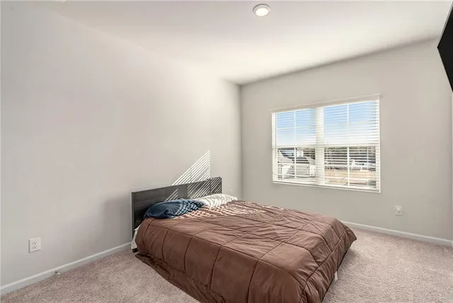 a bed sitting in a bedroom next to a window