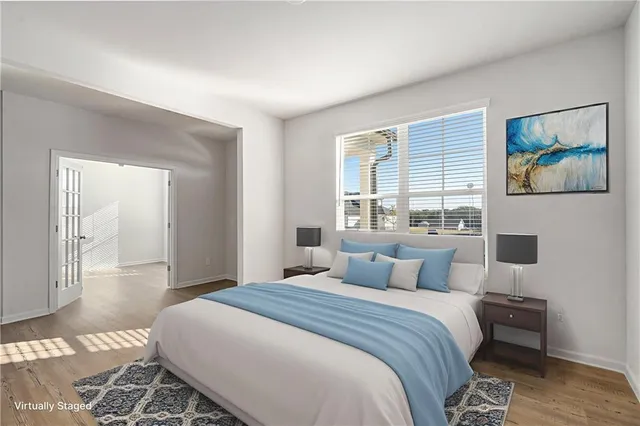 a bedroom with a large bed and a painting on the wall