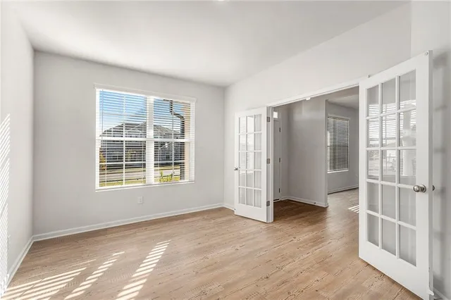 an empty room with wooden floor and windows