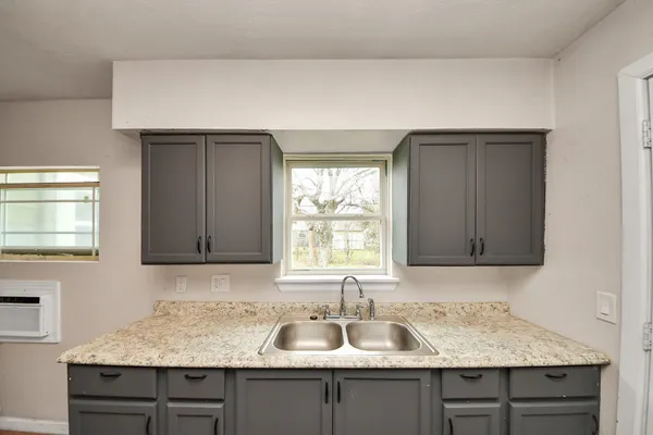 a kitchen with granite countertop a sink and a window