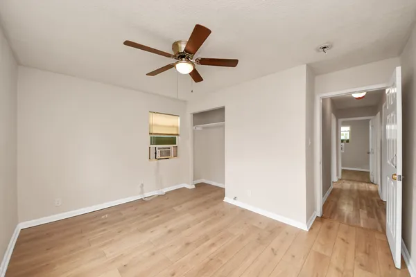 a view of a big room with wooden floor and windows