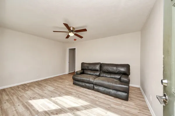a living room with furniture and a wooden floor