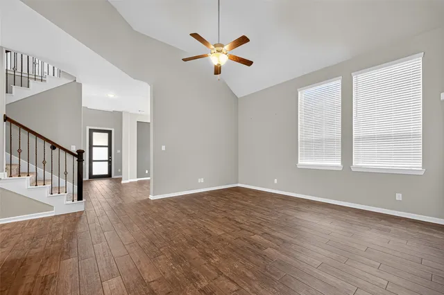 a kitchen with stainless steel appliances granite countertop a stove top oven a sink with wooden floors and cabinets