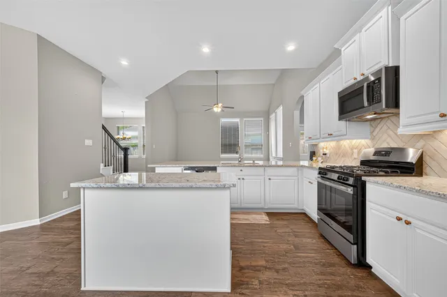 a kitchen with a stove and wooden floor