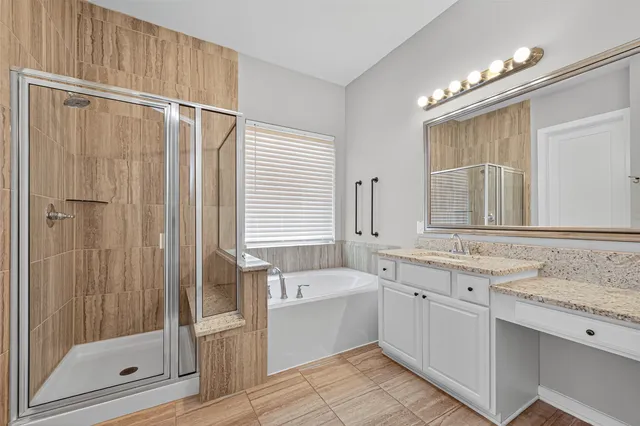 a bathroom with a tub double vanity sink and a mirror