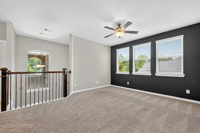 wooden floor in an empty room with a ceiling fan