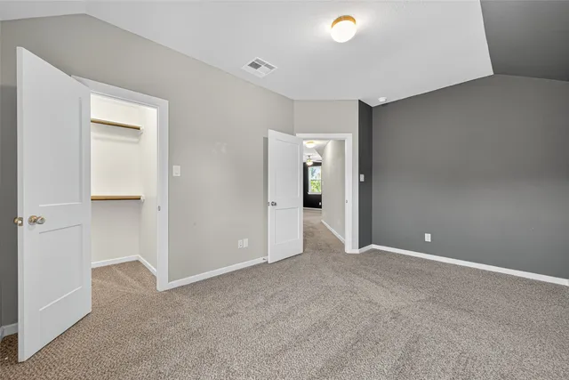 a spacious bedroom with a bed and a painting on the wall
