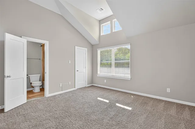 a spacious bedroom with a bed and a window