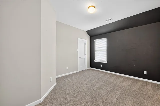 an empty room with closet and a window