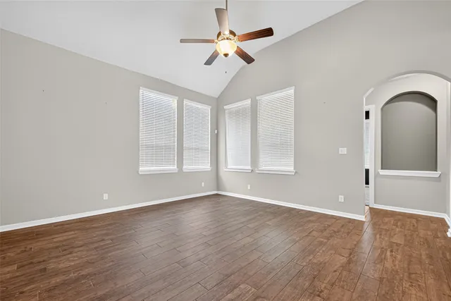 a view of an empty room with window and wooden floor