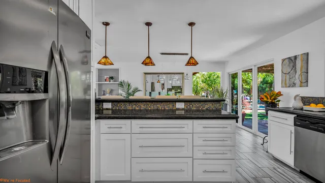 a kitchen with stainless steel appliances granite countertop a refrigerator and a stove top oven
