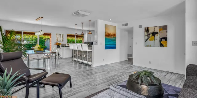 a view of a patio with couches table and chairs and potted plants