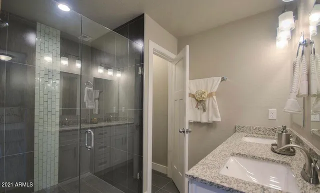 a bathroom with a granite countertop sink a shower and a mirror
