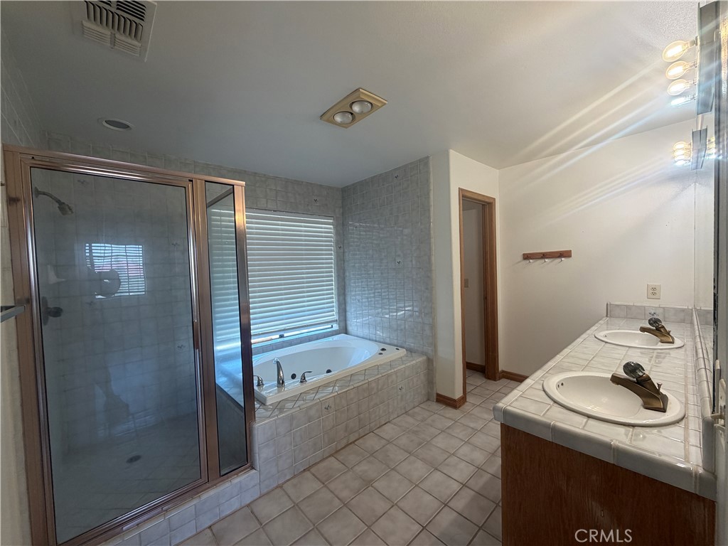 19609 Seneca Road Apple Valley, CA 92307 - Photo 23 of 37 a bathroom with a granite countertop sink a toilet and shower
