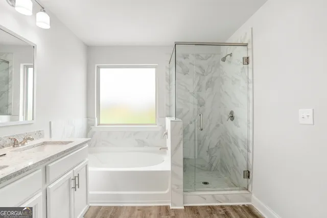 a bathroom with a granite countertop shower sink and a bathtub