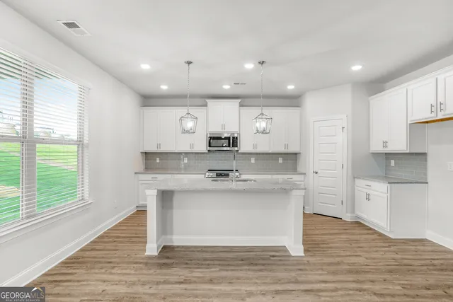 a kitchen with kitchen island sink stove and cabinets