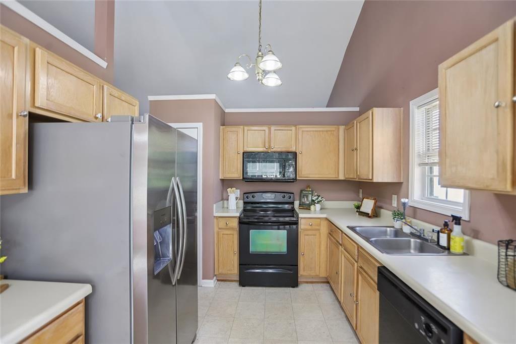 9720 Poole Road Villa Rica, GA 30180 - Photo 12 of 40 a kitchen with a refrigerator a sink a stove and cabinets