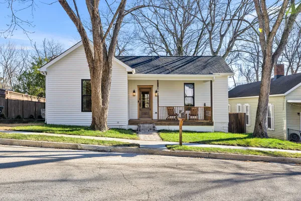 a view of a house with backyard and tree