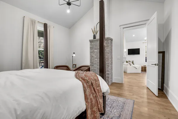 a bedroom with a bed and wooden floor