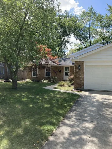 a front view of a house with yard and green space