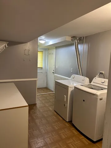 a view of a storage & utility room with two washing machine