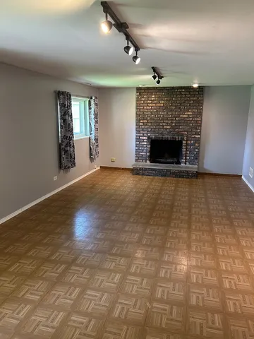an empty room with windows and fireplace