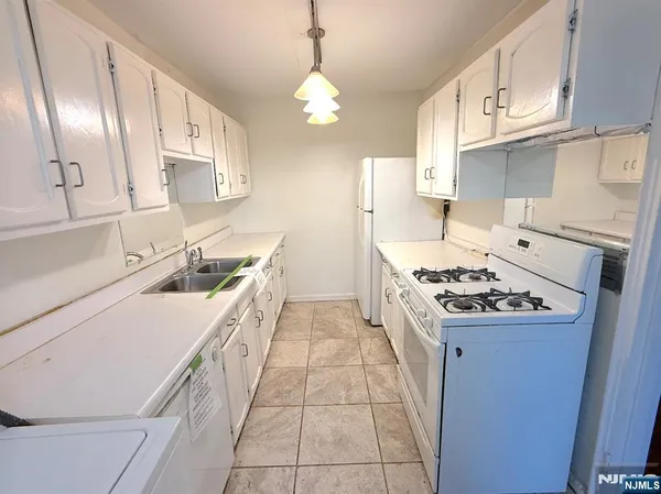 a kitchen with a stove a sink and a refrigerator